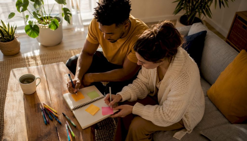 Couple writing shared marriage goals at kitchen table