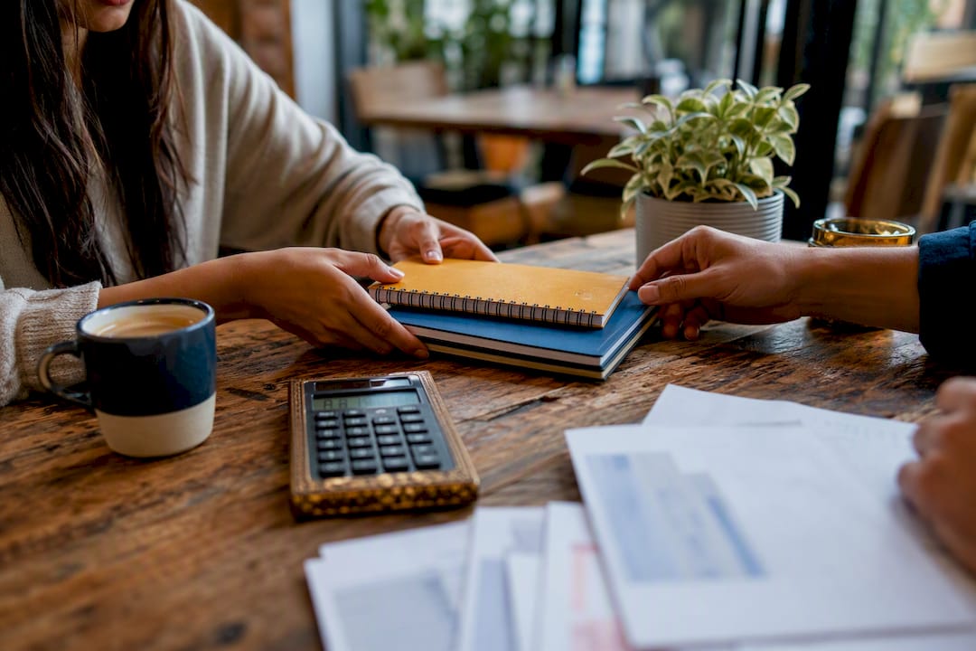 Hands organizing financial documents and calculator