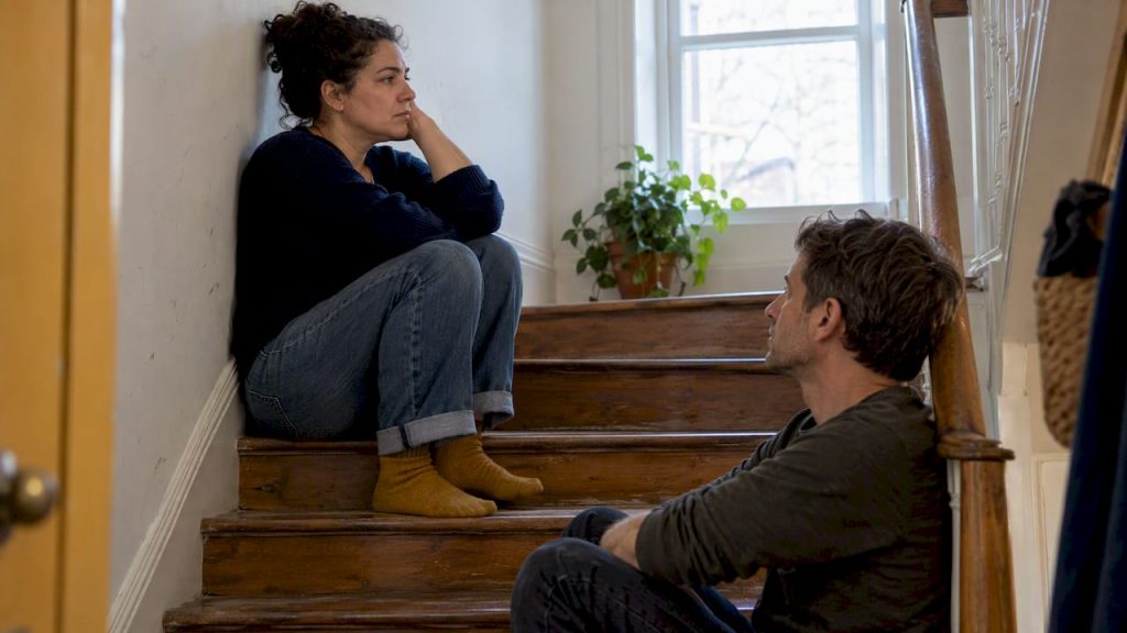 Partners taking space on apartment stairs